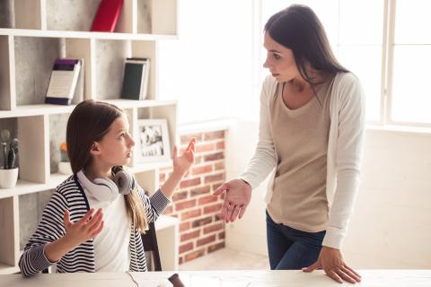 Mother and daughter having heated argument at kitchen table