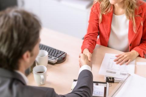 A client shakes hands with their lawyer.