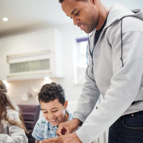 A father prepares breakfast for his kids.