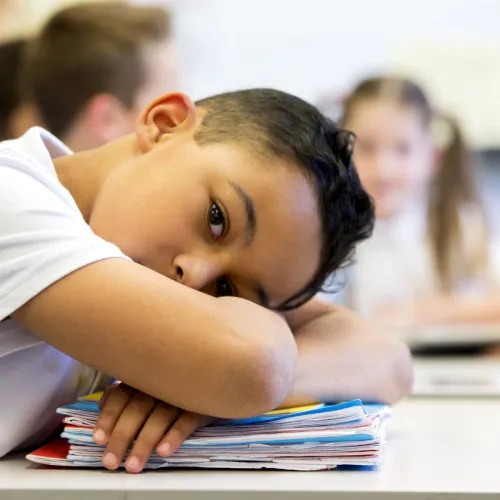 Young boy falls asleep at school.