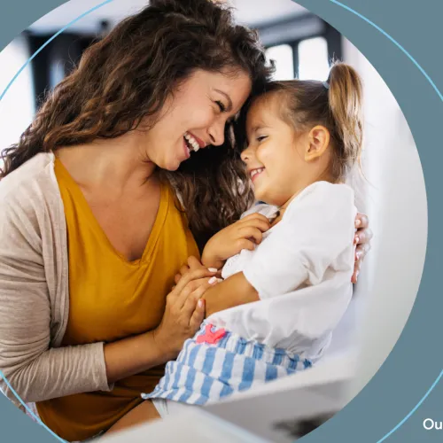 A mother smiles at her young daughter