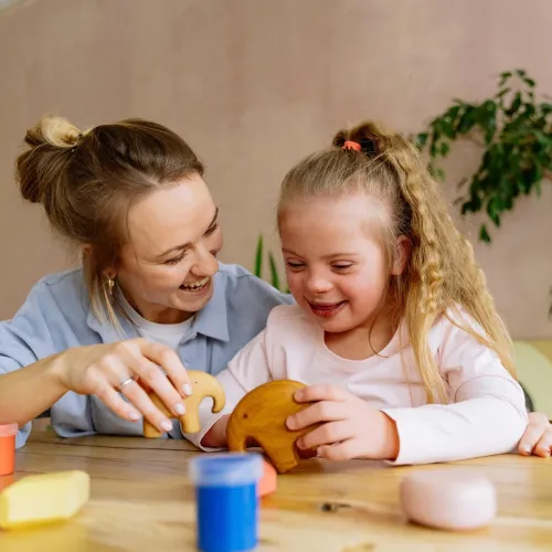 Mom and daughter playing with wooden toys. 
