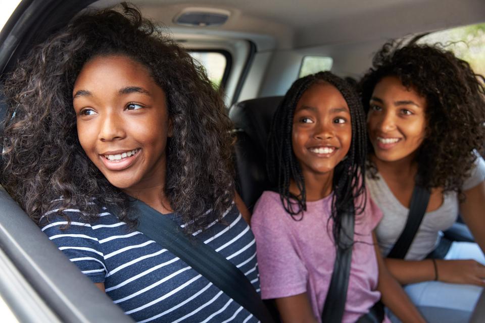 Three sisters look out the car window as they arrive at their parent's home.