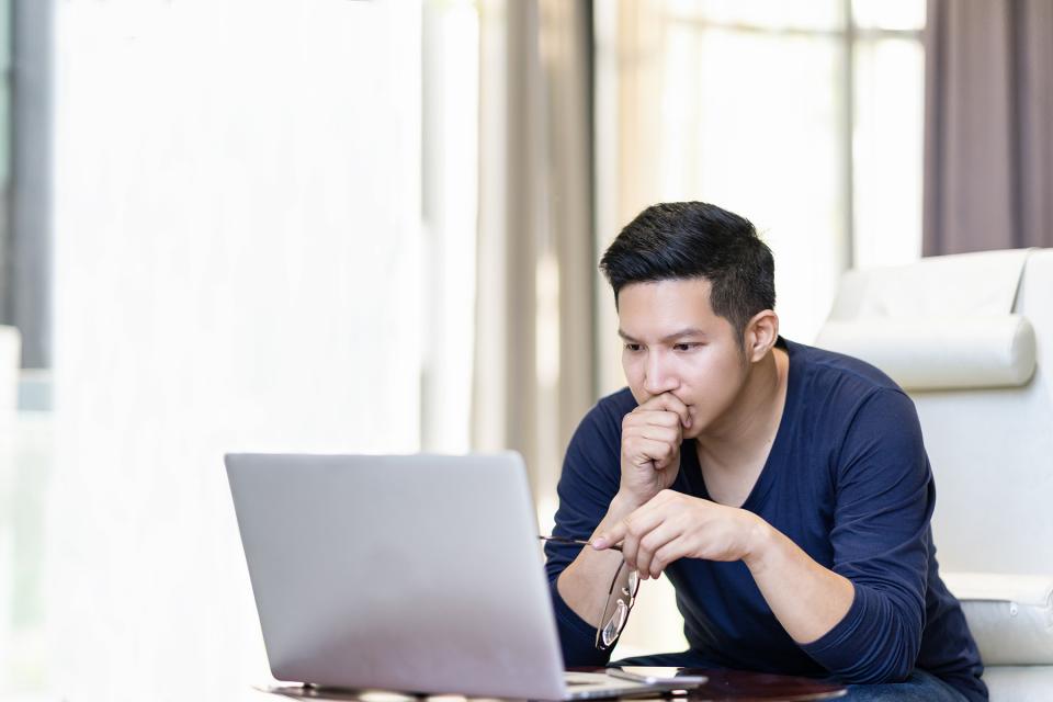 Man stares intently at his laptop as he researches which co-parenting app to choose.