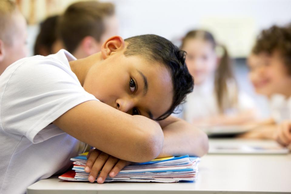 Young boy falls asleep at school.