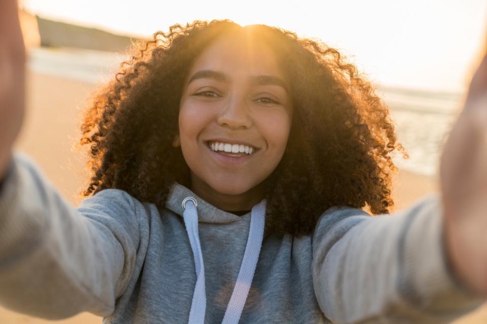 Teenage girl takes a selfie on the beach.
